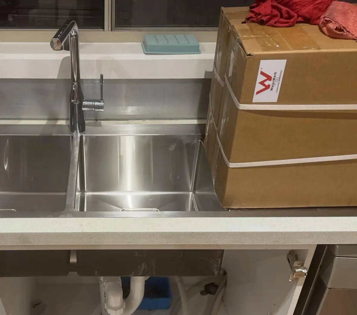 Newly installed stainless steel double kitchen sink and mixer tap