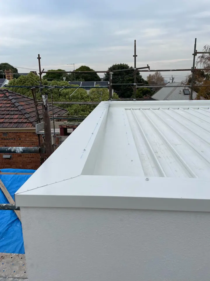 Newly installed profiled steel roof with a box gutter and neatly finished capping on a Melbourne extension
